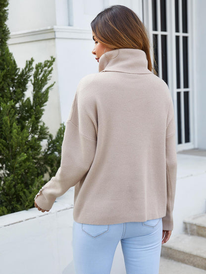 Beigefarbener Pullover mit hohem Kragen und Knopfdetails am Ärmel